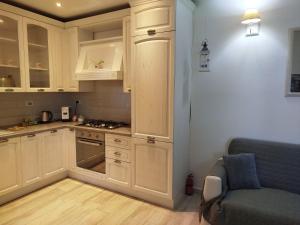 a kitchen with white cabinets and a blue couch at Appartamento al parco con parcheggio gratuito in Orbetello