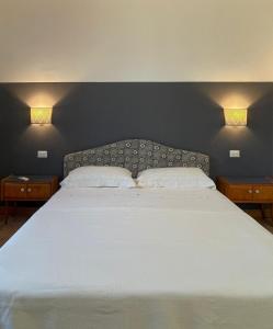 a bedroom with a large white bed with two night stands at La Pausa in Portoferraio +60 photos