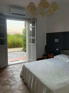 una camera con letto e porta scorrevole in vetro di La Pausa a Portoferraio