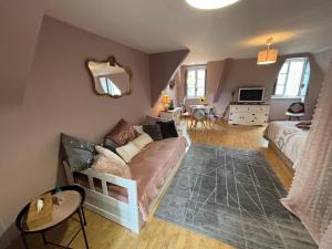 a living room with a couch and a bed at Le Grenier studio de charme centre historique in Dinan