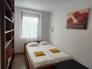 a bedroom with a bed with two towels on it at Tágas hely a parton in Balatonszárszó