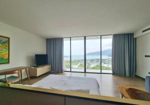 a hotel room with a bed and large windows at Villa Nha Trang Gần Biển - Biệt Thự Nha Trang Gần Biển in Nha Trang