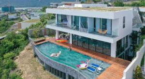 a house with a swimming pool with two people in it at Villa Nha Trang Gần Biển - Biệt Thự Nha Trang Gần Biển in Nha Trang