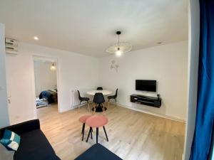 a living room with a table and chairs and a couch at Appartement rénover avec terrasse in Creil