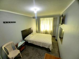 a bedroom with a bed and a chair and a window at Hospedaje D Francisco in Lima