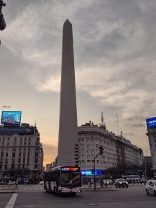 a bus driving in front of the washington monument at Depto torre Bayres Obelisco in Buenos Aires