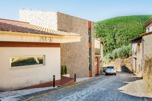 a street with a car parked on the side of a building at Entregredos in Guisando