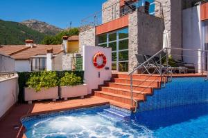 a house with a swimming pool and stairs next to a house at Entregredos in Guisando