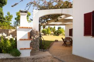 un patio con arco, tavolo e sedie di Quinta dos Malhadais, Figueira - Farm house a Portimão