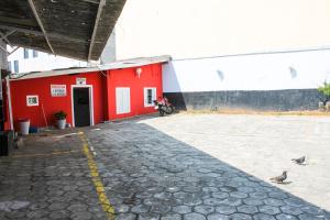 Un edificio rojo con una motocicleta estacionada enfrente. en Hotel Itaquera, en São Paulo