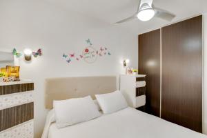 une chambre avec un lit blanc et une armoire marron dans l'établissement Esther Dream Bungalow, à Mogán 18 autres photos