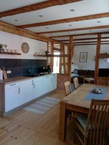a kitchen with a table and a clock on the wall at Ferienwohnung Gisela 80qm in Gernrode - Harz