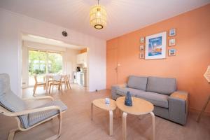 a living room with a couch and chairs and a table at La Rafale rez de chaussée - Accès Privée à la plage in Grand-Fort-Philippe