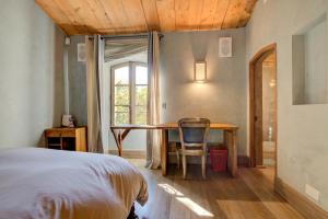 a bedroom with a bed and a table and a window at MAS DES CIGALES Lambesc in Lambesc +102 photos