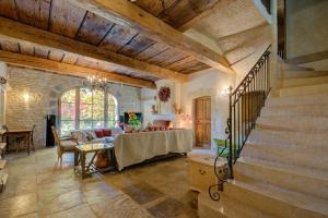 a living room with a table and a staircase at MAS DES CIGALES Lambesc in Lambesc
