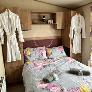 a bedroom with a bed with flowers on it at Bianca and marks 8 berth Caravan with Hot tub in Tattershall
