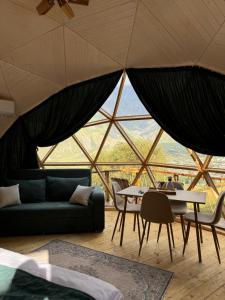 una sala de estar con un sofá y una mesa en Glamping EmeralD, en Kazbegi