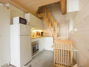 a small kitchen with a refrigerator and a staircase at Pieni Katajaranta in Karvonen