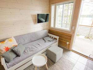 a living room with a couch and a tv at Pieni Katajaranta in Karvonen