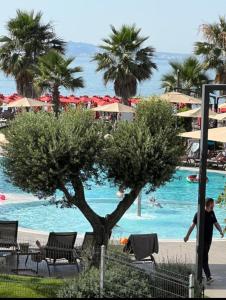 a man walking by the pool at a resort at Apartments Qerret Golem beachfront in (( Stan i Ri ))