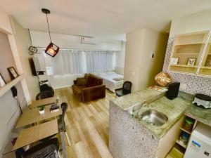 een keuken en een woonkamer met een wastafel en een bank bij Flat Boa Viagem luxo in Recife