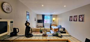 巴斯洛内特Grand studio 3 personnes idéalement placé的客厅里有一张沙发，墙上挂着一只钟