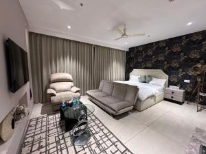 ein Schlafzimmer mit einem Bett, einer Couch und einem Sessel in der Unterkunft Luxury Studios Key 3 in Gurgaon