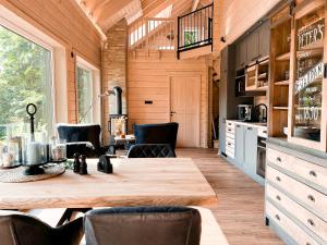 a kitchen with a wooden table and black chairs at Hercynia Lodge in Bad Lauterberg +35 photos