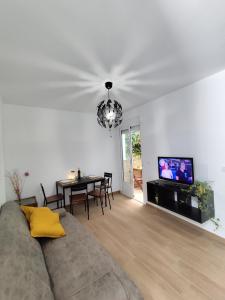 een woonkamer met een bank, een tafel en een televisie bij Apartamento Artesano Del Cuero SpaceWorking in Ubrique