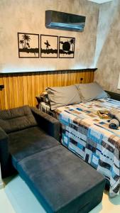 a bed and a couch in a room at Roda Gigante, garagem e piscina in Balneário Camboriú +24 photos