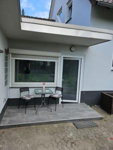 a patio with a table and chairs and a window at Charmante ruhige Oase in Lehrte
