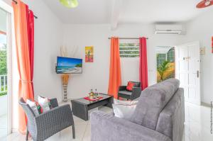 a living room with a couch and two chairs at Cannelle au Refuge de Madiana à Schoelcher in Schœlcher