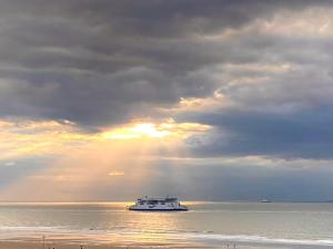 a boat in the ocean under a cloudy sky at Studio La Matelote in Calais +6 photos