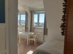 a bedroom with a table and a room with a window at Studio La Matelote in Calais