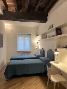 - une chambre avec 2 lits bleus et un bureau dans l'établissement Appartamento San Gallo Cremona Centro, à Crémone