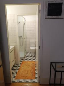 a bathroom with a toilet and a shower and a rug at Porto Histórico - pet friendly in Porto