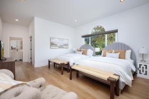 two beds in a white room with a bench at Casa Blanca Estate Lux 5BR4BA in San Antonio +89 photos