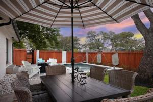 a wooden table with an umbrella on a patio at Casa Blanca Estate Lux 5BR4BA in San Antonio