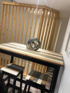 Un neumático sobre una mesa de madera con dos taburetes. en Appartement à proximité d’Epinal avec climatisation, en Dogneville