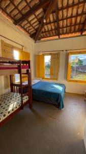 a bedroom with two bunk beds and two windows at HOSTEL DA LU e HOSPEDAGEM FATIMA in Pirenópolis