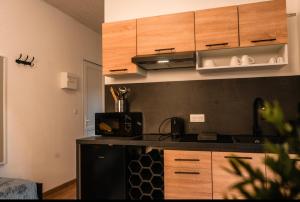 a kitchen with wooden cabinets and a black counter top at Le symphonie in Gray