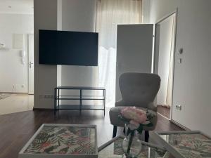 a living room with a chair and a tv at Apartment Merkur in Vienna