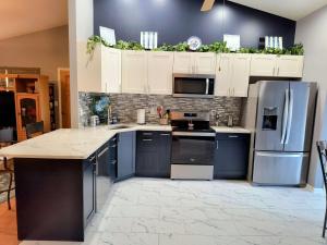 a kitchen with white cabinets and blue appliances at Hot Tub Hideaway 3 BR in Jeffersonville