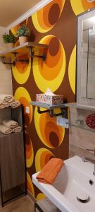 a bathroom with a sink and a colorful wall at Ferienhaus Wald-Idyll Meisdorf in Meisdorf +20 photos