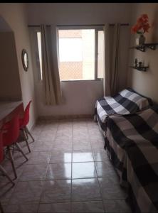 a room with a bed and a table and a window at Apartamento in Solemar