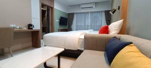 a hotel room with a bed and a couch at Bangkok Mystay Hotel Rangsit in Thanya Buri