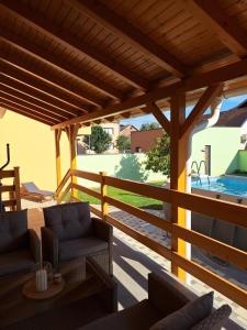 a wooden pergola with couches on a patio at Apartman Cherry in Višnjevac