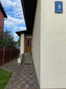 a building with a door and a brick walkway at Private house in Valmiera