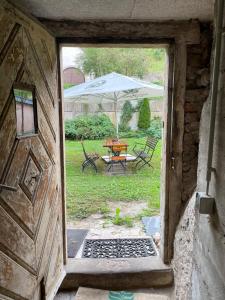 Una puerta abierta a un patio con una mesa y una sombrilla. en Haus Ella, en Stühlingen