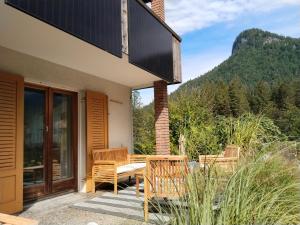 a patio with two chairs and a balcony with a mountain at am Fluhbach in Mellau